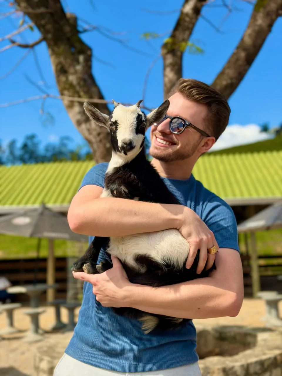 Visitante sorrindo com um cabritinho no colo